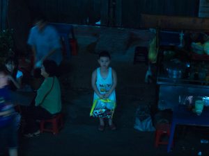 Ho- Chi- Minh city, city district, at night, kid looking up, aim-frame photography